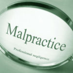A magnifying glass that reads malpractice