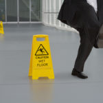 Man in suit slipping on wet floor