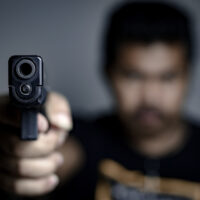 Man is shooting a gun , selective focus on front gun,use for add text