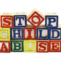 The words Stop Child Abuse in colorful wooden blocks 1/2