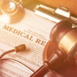 Wooden gavel and stethoscope on wooden background