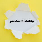 PRODUCT LIABILITY word written under torn paper.