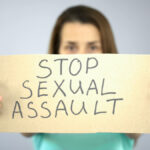 Stop sexual assault sign in womans hands, female rights protection, awareness